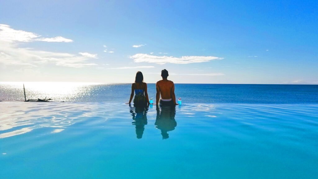 Couple in the infinity pool looking at the sea